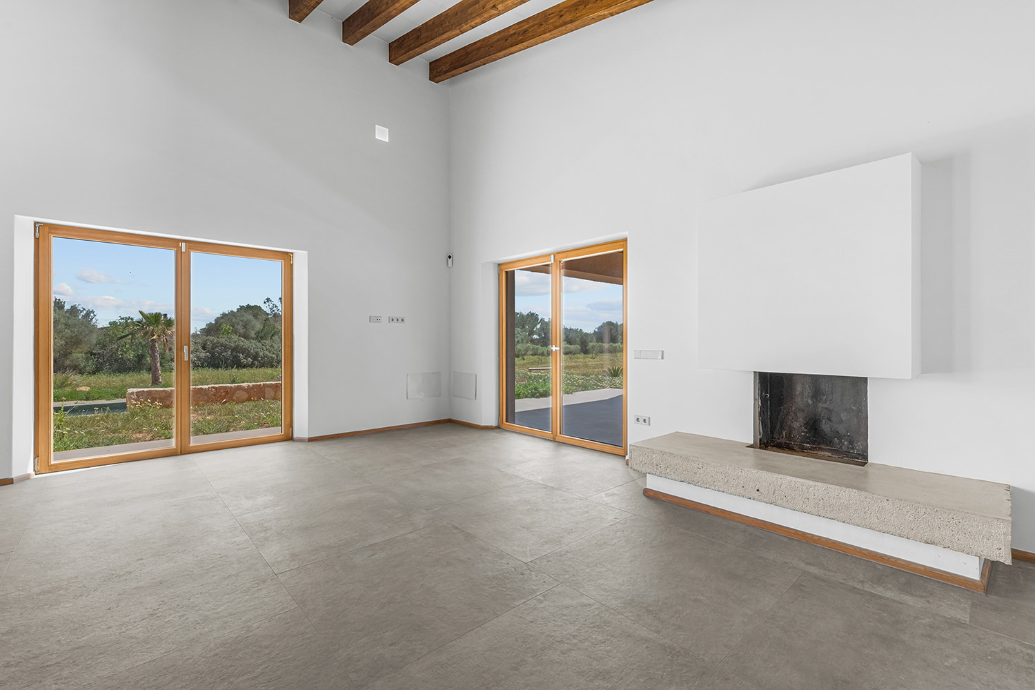 Wohnzimmer mit Kamin und großzügigen Fensterflächen