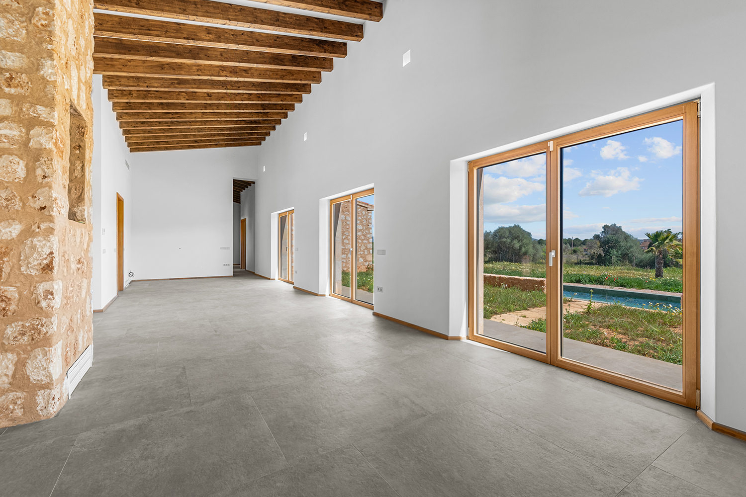 Großzügiger Flur mit Sichtachse, Holzbalken und Fensterfronten