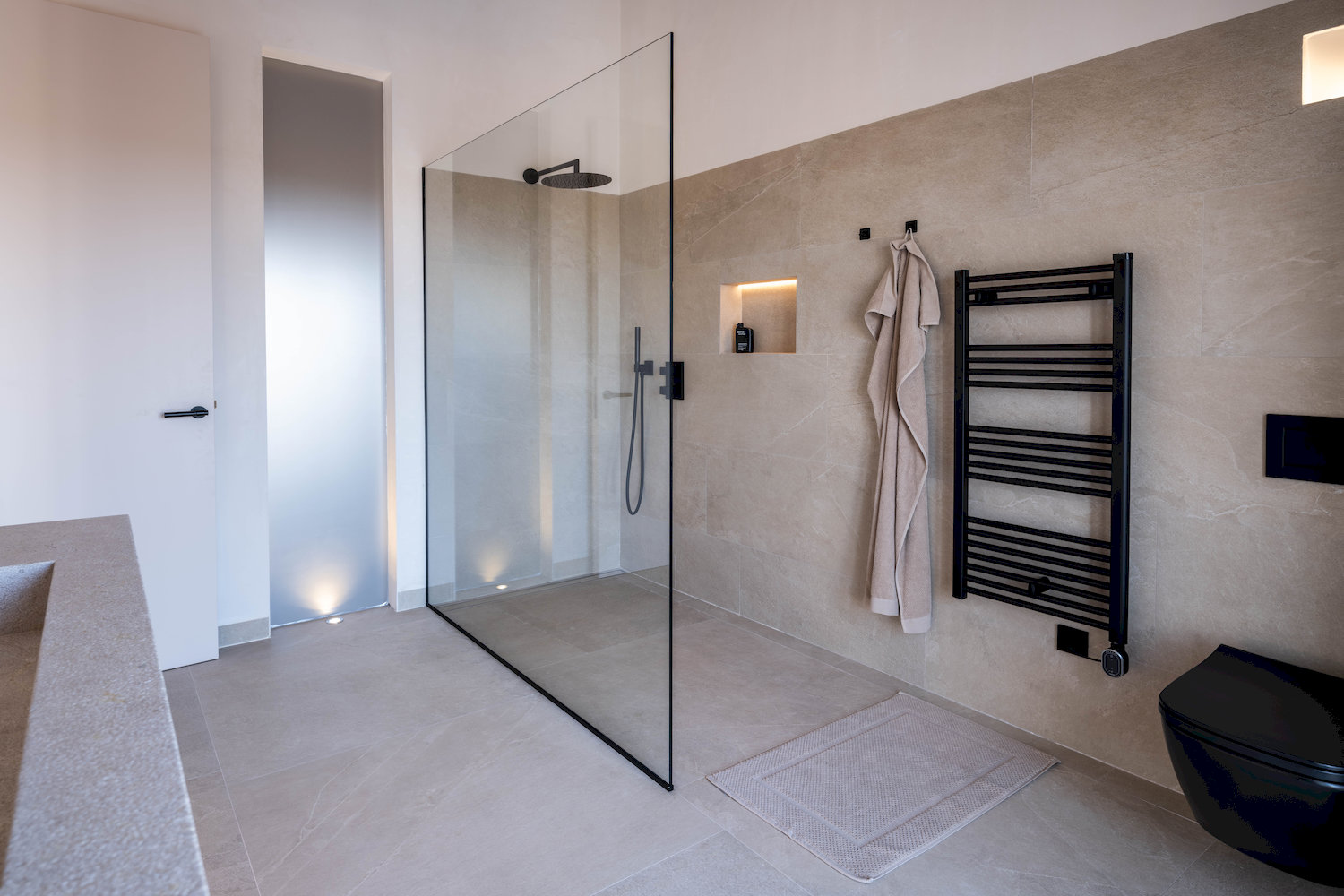 Modernes Bad mit bodengleicher Dusche und klarer Linienführung