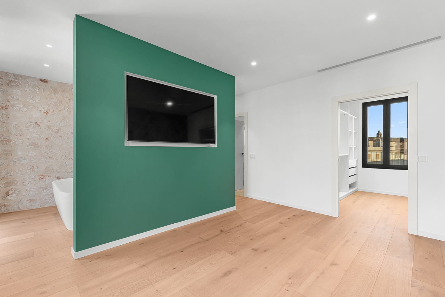 Masterschlafzimmer mit freistehender Badewanne