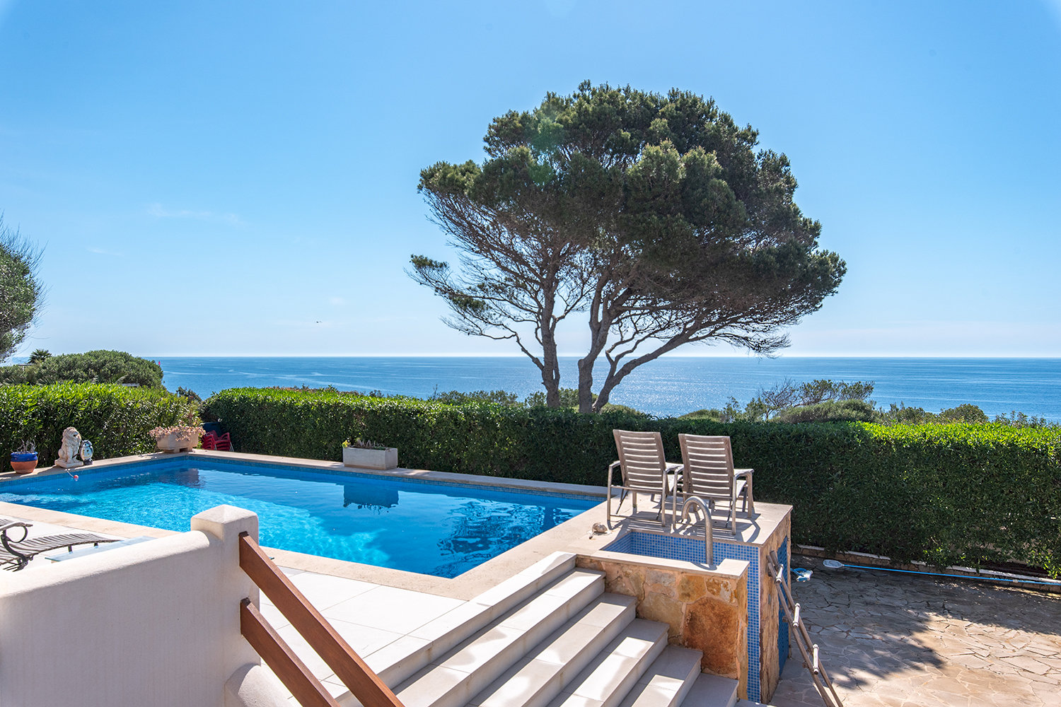 Stilvoller Poolbereich mit Loungezonen und direktem Meerblick