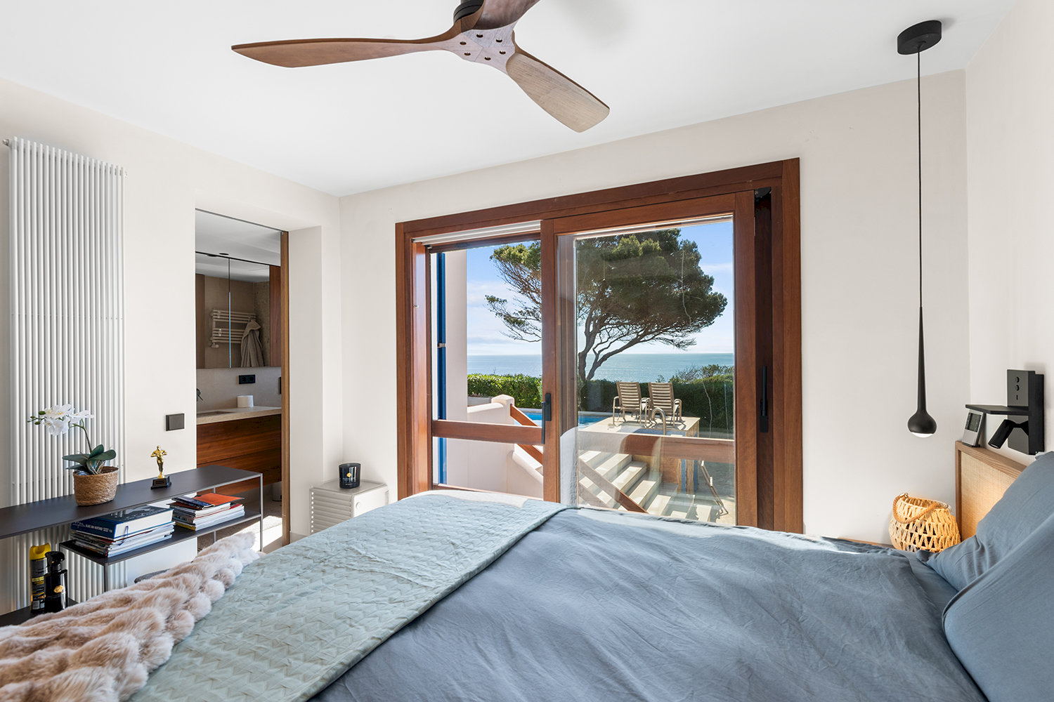 Schlafzimmer mit Zugang zur Terrasse und Poolblick