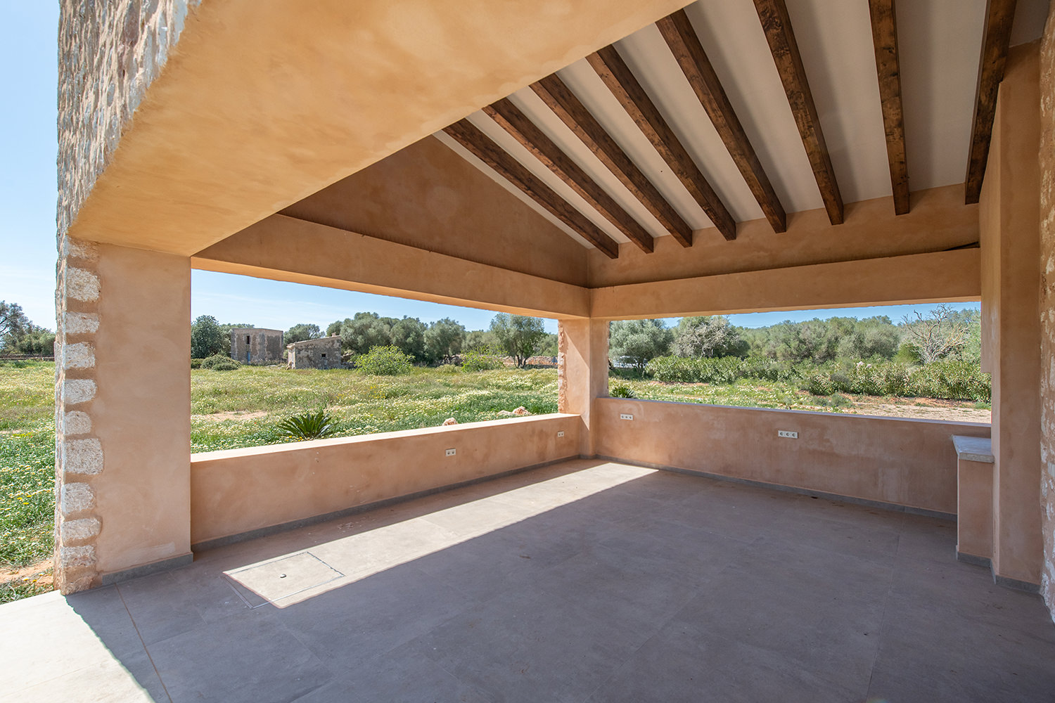 Überdachte Eckterrasse mit Weitblick und sichtbaren Holzbalken