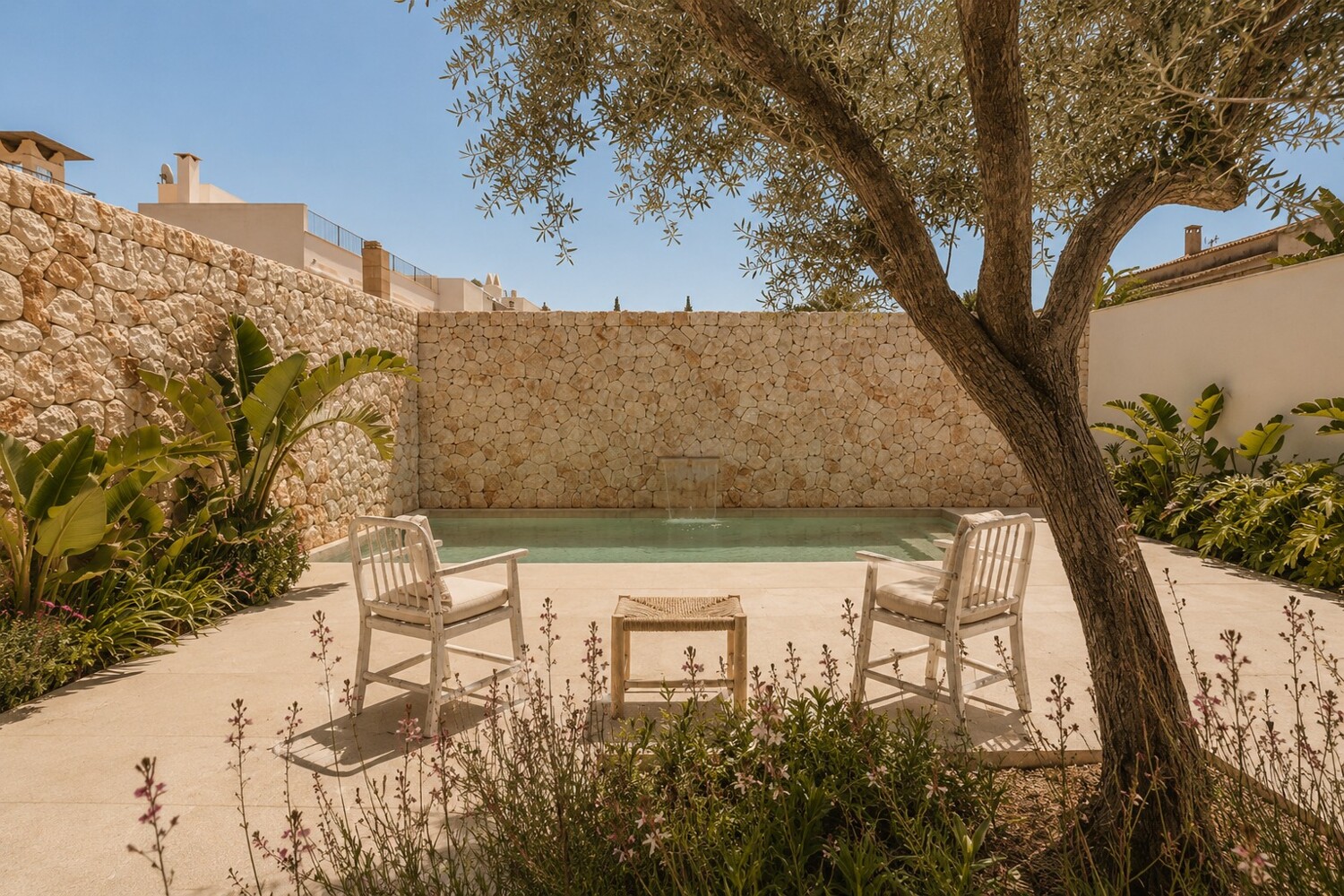 Privater Außenbereich mit Pool, Aufenthaltszonen und Natursteinmauer als hochwertiger Grundstückseinfassung