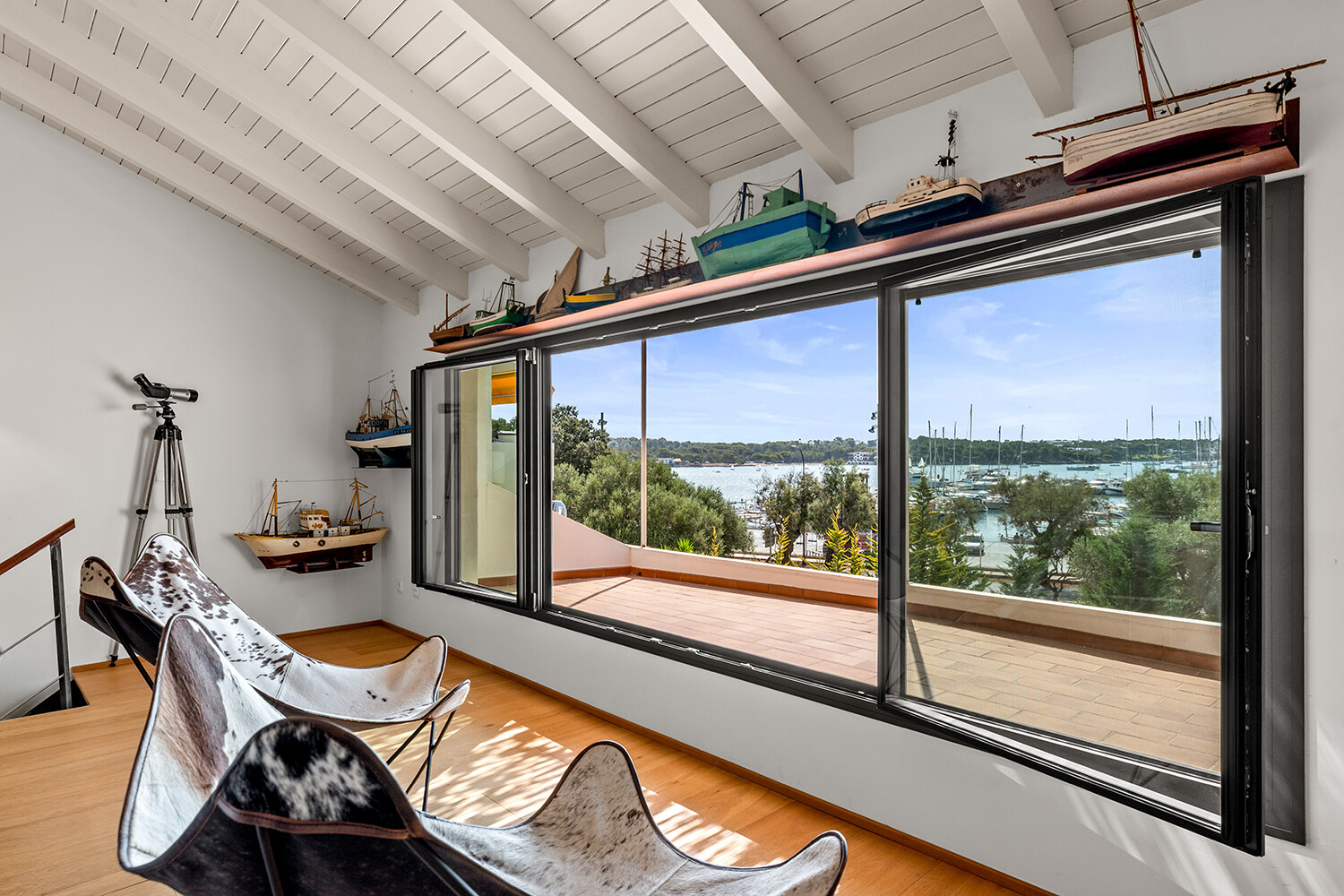 Exklusiver Rückzugsbereich im Dachgeschoss mit weitläufiger Fensterfront und eindrucksvollem Panoramablick auf den Yachthafen