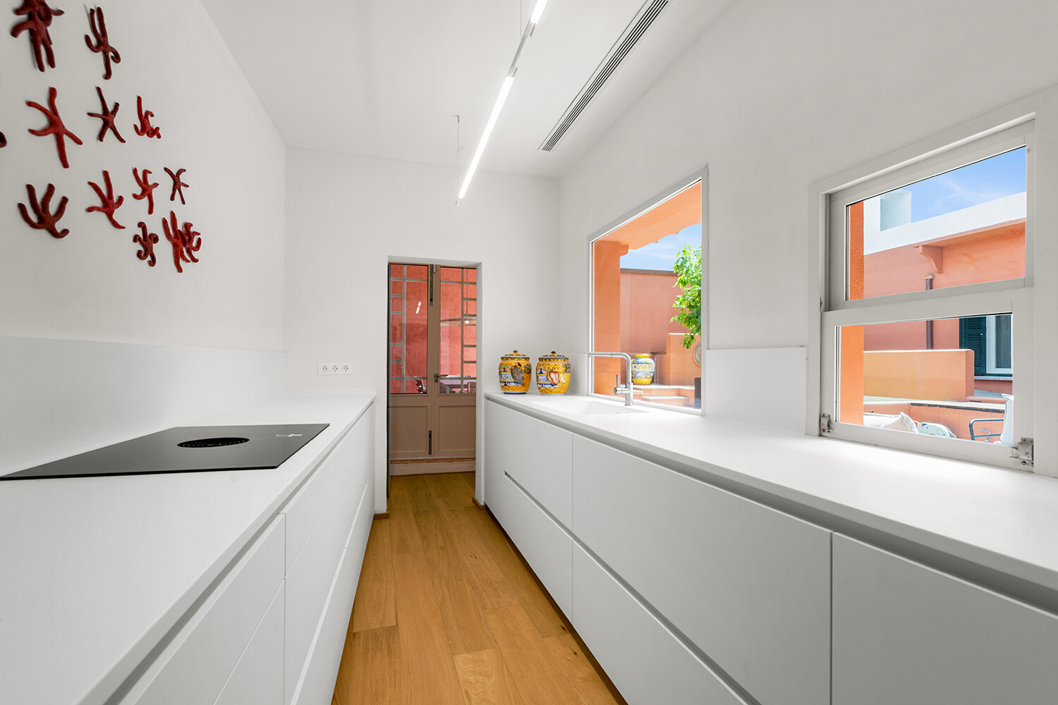 Minimalistische Designküche mit grifflosen Einbauten und direktem Bezug zum Innenhof