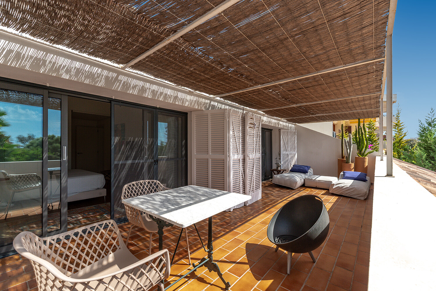Großzügige, beschattete Terrasse mit verschiedenen Sitz- und Liegebereichen für entspanntes Outdoor-Living